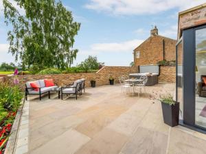 a patio with furniture and a brick wall at 2 Bed in Northallerton oc-83398 in Brompton +9 photos