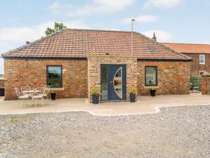 a brick house with a patio with a table and chairs at 2 Bed in Northallerton oc-83398 in Brompton