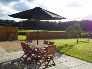 a table and chairs with an umbrella on a patio at 2 Bed in Chew Magna oc-chela in Stowey