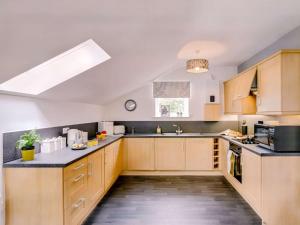 a large kitchen with wooden cabinets and a window at 1 Bed in Holmfirth oc-88554 in Holmfirth +7 photos