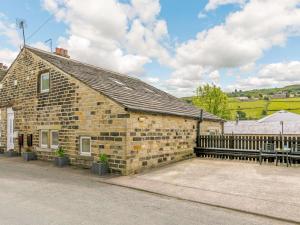 a brick building with a fence and a table and an umbrella at 1 Bed in Holmfirth oc-88554 in Holmfirth