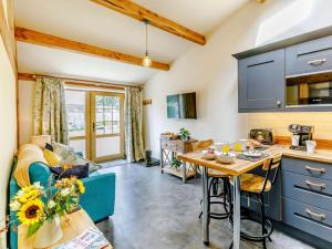 a kitchen and living room with blue cabinets and a table at 1 Bed in Ripon oc-85511 in Masham