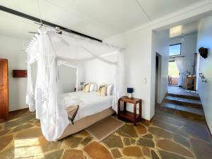 a bedroom with a bed with a canopy at Cheetah View Lodge at Cheetah Conservation Fund in Otjiwarongo