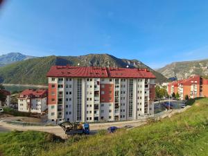 a large apartment building with a mountain in the background at Apartman PETRA QUEEN in Plužine