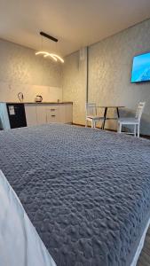 a large bed in a room with a table and chairs at 1 комнатные апартаменты 4а 67 in Semey