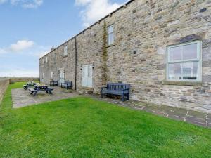 a brick building with benches next to a grass yard at 3 Bed in Consett oc-29408 in Lanchester