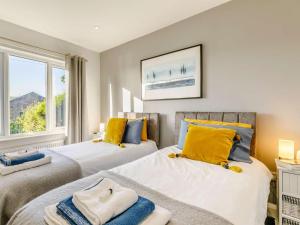 a bedroom with two beds with yellow and blue pillows at 2 Bed in Bradford oc-75164 in Thornton