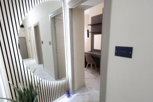 ein Spiegel in einem Flur mit einem Zimmer in der Unterkunft GioielliPlace in Capodrise