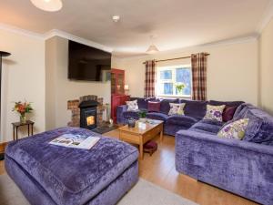 a living room with a purple couch and a fireplace at 5 Bed in York oc-77267 in Green Hammerton