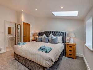 a bedroom with a large bed with blue pillows at 3 Bed in York oc-93898 in Tollerton