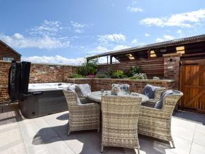 a patio with a table and chairs and a hot tub at 3 Bed in York oc-93898 in Tollerton