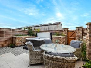 a patio with a table and chairs and a grill at 3 Bed in York oc-93896 in Tollerton