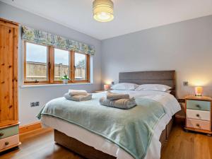 a bedroom with a large bed with two pillows on it at 2 Bed in Axbridge oc-91358 in Loxton