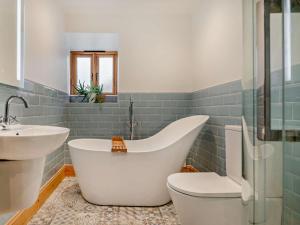 a bathroom with a white tub and a sink at 2 Bed in Axbridge oc-91358 in Loxton +15 photos