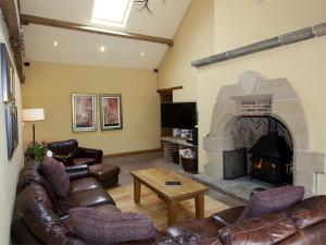 a living room with leather furniture and a stone fireplace at 4 Bed in Slingsby oc-g0146 in Hovingham