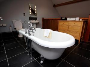 a bathroom with a tub and a toilet and a sink at 4 Bed in Slingsby oc-g0146 in Hovingham +5 photos