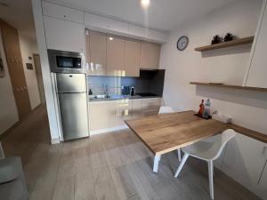a kitchen with a wooden table and a refrigerator at Costa Adeje Fañabé Beach Apartment in Adeje