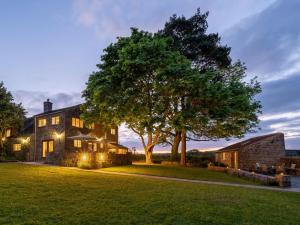 a large house with a tree in the yard at 8 Bed in Ripon oc-72263 in Grantley