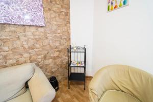 a living room with two chairs and a stone wall at Edificio Prieto VIV 2B in Puerto del Rosario