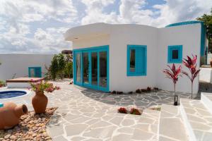 a villa with blue windows and a swimming pool at Olymp Spa Boutique Hotel in Monte das Gameleiras