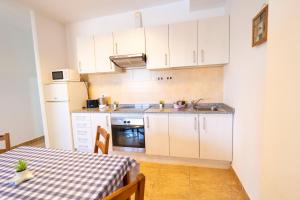 a small kitchen with white cabinets and a table at Edificio Prieto VIV 2B in Puerto del Rosario