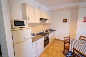 a kitchen with white cabinets and a sink and a microwave at Edificio Prieto VIV 2B in Puerto del Rosario +31 photos