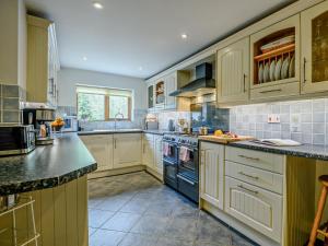 a large kitchen with white cabinets and a blue oven at 4 Bed in Lymington oc-nfl94 in Sway