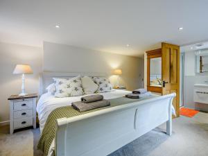 a bedroom with a large white bed with towels on it at 4 Bed in Lymington oc-nfl94 in Sway
