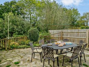 a patio with a table and chairs and a fence at 4 Bed in Lymington oc-nfl94 in Sway