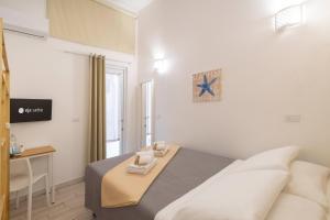 a bedroom with a bed and a desk in it at Approdo Rooms - Eja Sardinia in Cagliari