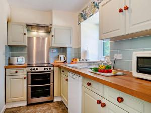 a kitchen with white cabinets and a counter with fruits and vegetables at 3 Bed in Dorchester oc-92414 in Frome Vauchurch