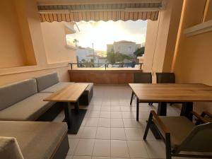a restaurant with two tables and a couch and a window at Costa Adeje Fañabé Beach Apartment in Adeje +65 photos