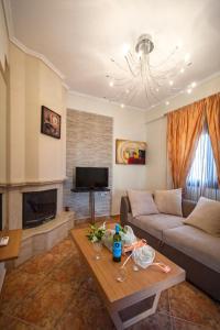 a living room with a couch and a table at Αmalia Lux Villas in Nea Vrasna