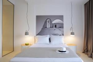 a bedroom with a bed with a hat on it at Livin Mykonos Hotel - Adults Only by Mr and Mrs White in Mikonos