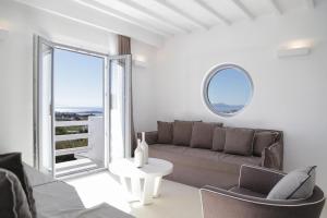 a living room with a couch and a large window at Livin Mykonos Hotel - Adults Only by Mr and Mrs White in Mikonos +86 photos