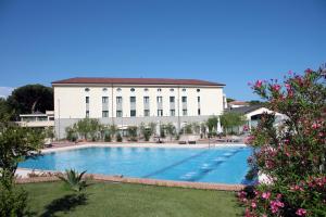 a building with a large swimming pool in front of a building at Grand Hotel Paestum in Paestum