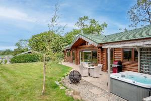 a log cabin with a hot tub in the yard at Penhill in Constable Burton
