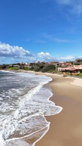 a beach with waves coming in from the ocean at Casa Antonietta - SHARDANAPARTMENTS in Iglesias
