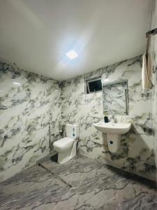 a bathroom with a toilet and a sink at Monaco Guest House in Devinuwara