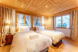 two beds in a bedroom with two windows at Chalet Eclipse, The Hidden Wonder in Hornkessel