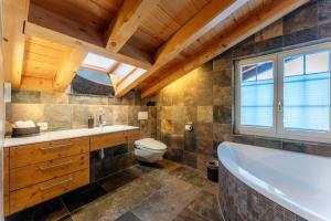 a bathroom with a tub and a toilet at Chalet Eclipse, The Hidden Wonder in Hornkessel +18 photos