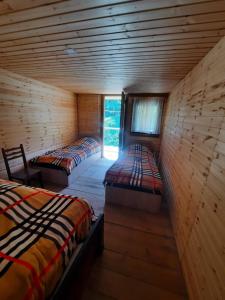 a room with two beds in a wooden cabin at Dartlo Hotel in Dart'lo