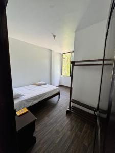a small room with a bed and a window at Puyo River Room in Puyo