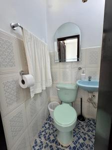 a bathroom with a toilet and a sink and a mirror at Puyo River Room in Puyo