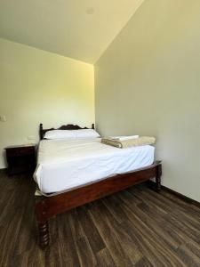 a bedroom with a bed with white sheets on it at Puyo River Room in Puyo