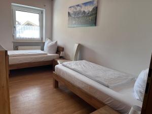 a room with two beds and a window at Ferienwohnung zum Breu im Löwen in Reit im Winkl