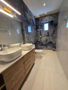 a bathroom with two sinks and a shower at Panorama Serenity Suites in Thessaloniki