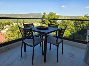 a table and chairs on a balcony with a view at Panorama Serenity Suites in Thessaloniki