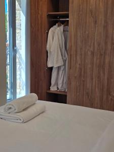 a bedroom with a bed and a closet with towels at Panorama Serenity Suites in Thessaloniki