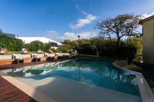 a swimming pool in a yard with chairs and trees at Casa Portuguesa - Charming House in Ponta Delgada